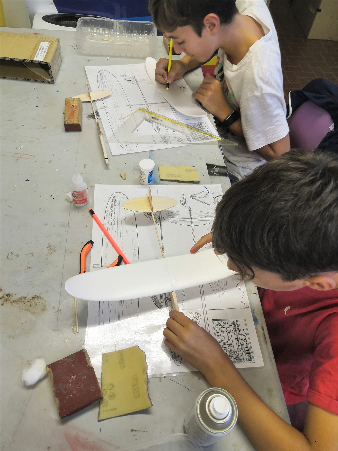 Ragazzi al lavoro sulla costruzione di un'ala