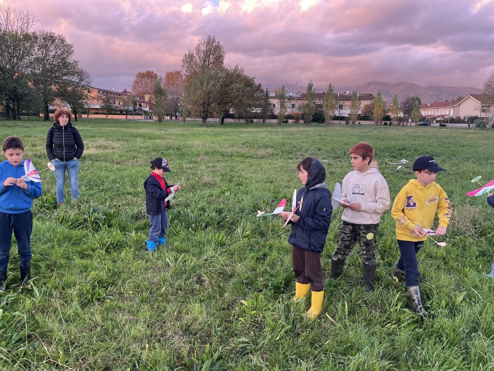 I ragazzi in campo con i loro modelli sotto il cielo di novembre